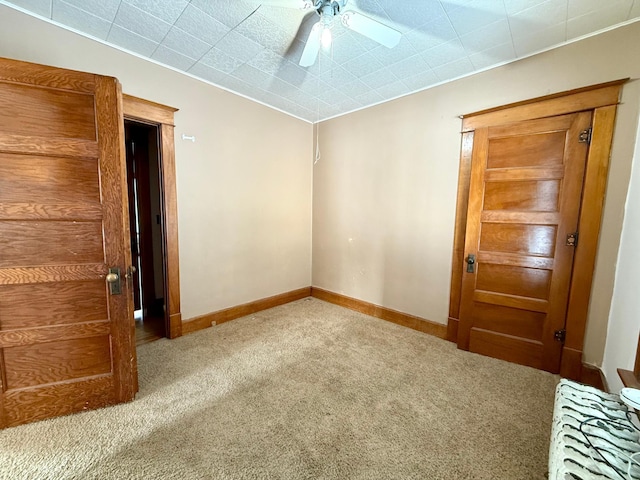 carpeted spare room with ceiling fan