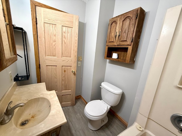 bathroom featuring sink, wood-type flooring, and toilet