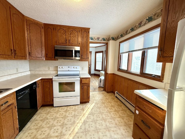 kitchen with baseboard heating, wood walls, a textured ceiling, and white appliances