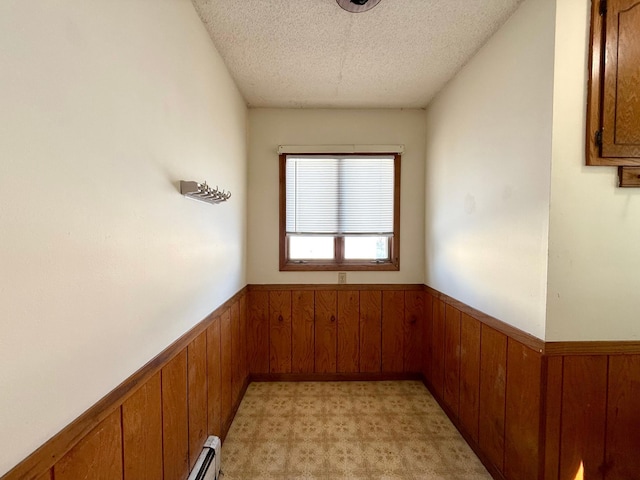 carpeted empty room featuring wooden walls and a textured ceiling