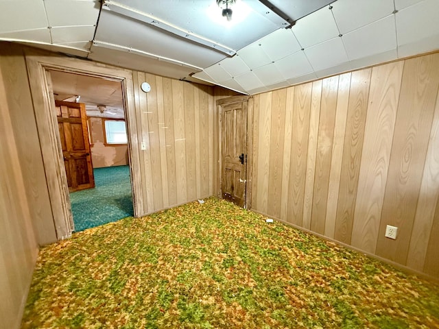 hall with carpet flooring and wooden walls