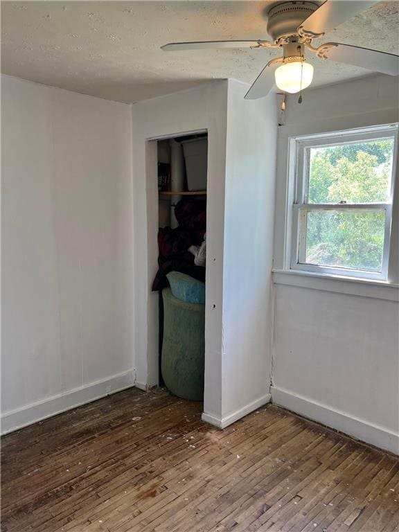 unfurnished bedroom featuring ceiling fan, a closet, and wood-type flooring