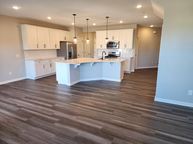 kitchen with decorative light fixtures, appliances with stainless steel finishes, and white cabinetry