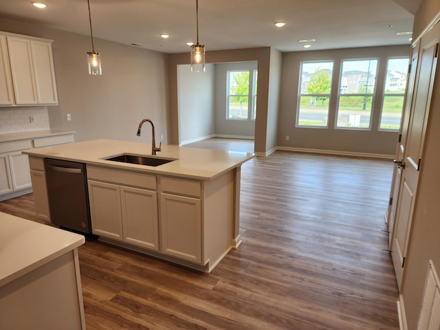 kitchen with dishwasher, sink, dark hardwood / wood-style floors, decorative light fixtures, and a center island with sink