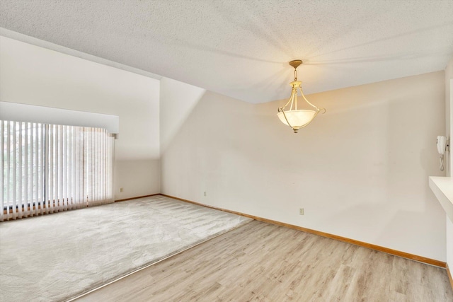 unfurnished room with wood-type flooring and a textured ceiling