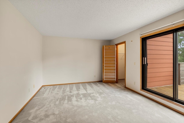 carpeted spare room featuring a textured ceiling