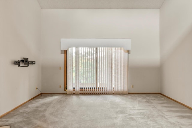 carpeted empty room with a textured ceiling