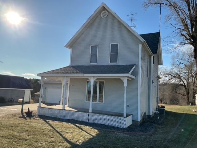 view of front facade with covered porch, a garage, and a front yard