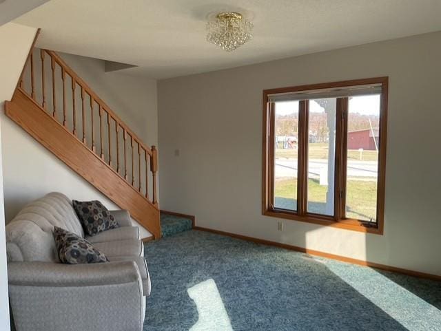 carpeted living room with an inviting chandelier