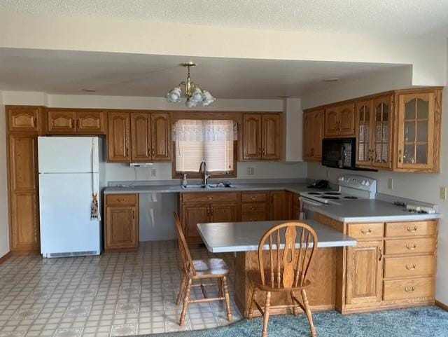 kitchen with white appliances, sink, decorative light fixtures, a notable chandelier, and a breakfast bar area