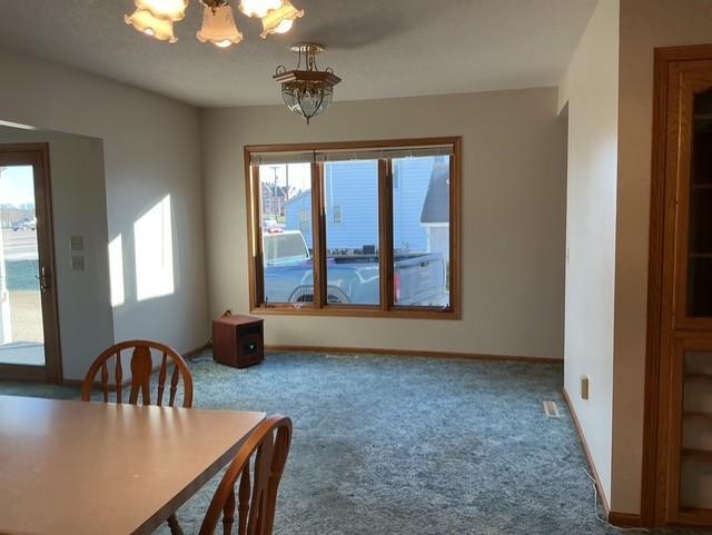 unfurnished dining area with carpet and an inviting chandelier