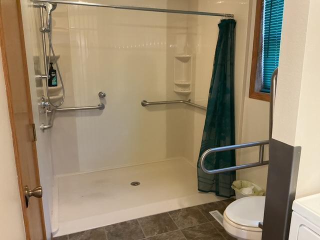 bathroom with a shower with curtain and toilet