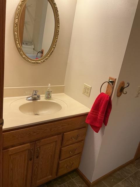 bathroom with vanity, stacked washer and dryer, and tile patterned floors