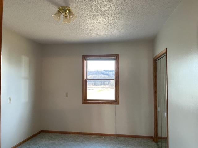 spare room featuring a textured ceiling and carpet floors