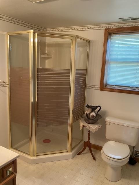 bathroom featuring vanity, an enclosed shower, and toilet