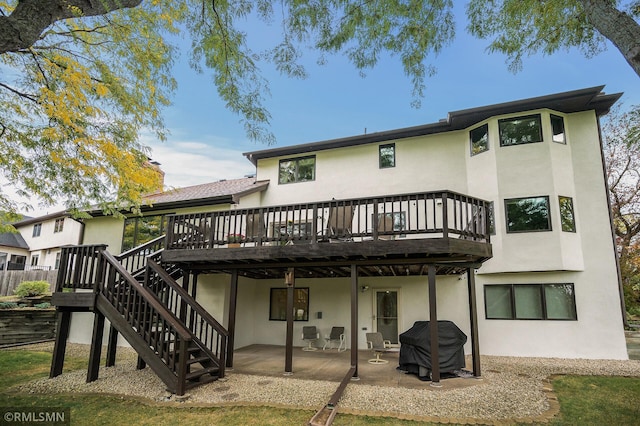 rear view of house with a patio and a wooden deck