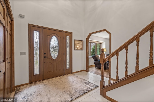 entryway with light tile patterned floors and a high ceiling