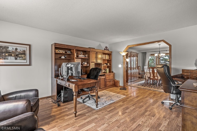 office with a chandelier, a textured ceiling, and light hardwood / wood-style floors