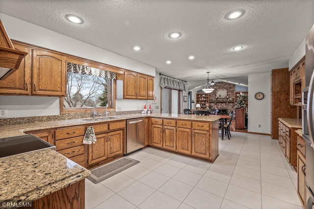 kitchen with stainless steel dishwasher, kitchen peninsula, pendant lighting, vaulted ceiling, and a textured ceiling