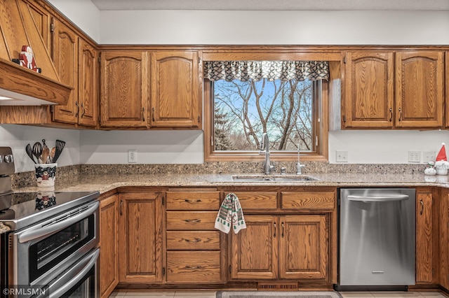 kitchen featuring light stone countertops, sink, and appliances with stainless steel finishes