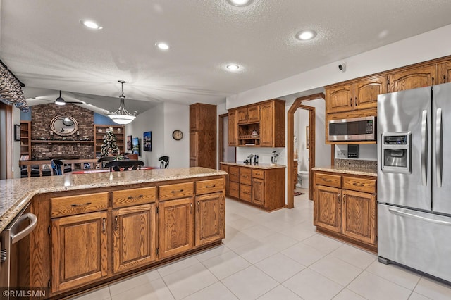 kitchen with lofted ceiling, a textured ceiling, decorative light fixtures, light tile patterned flooring, and stainless steel appliances