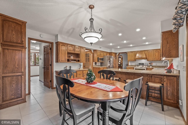 tiled dining space with a textured ceiling and sink