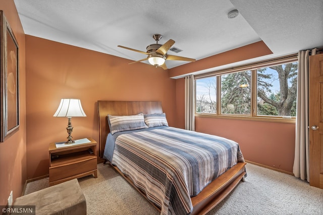 carpeted bedroom featuring ceiling fan, a closet, and a textured ceiling