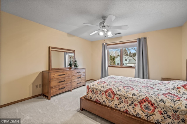 carpeted bedroom featuring a textured ceiling and ceiling fan