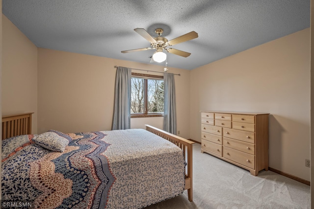 bedroom featuring ceiling fan, light carpet, and a textured ceiling