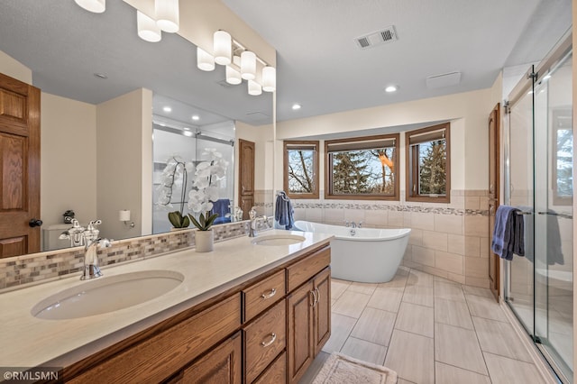 bathroom featuring separate shower and tub, tile patterned floors, a textured ceiling, vanity, and tile walls