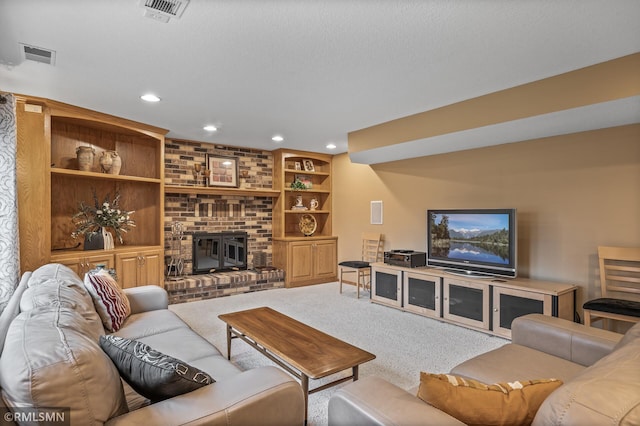 living room featuring built in shelves, carpet floors, and a brick fireplace