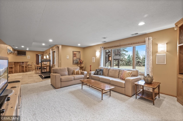 carpeted living room featuring indoor bar and a textured ceiling