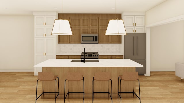 kitchen featuring appliances with stainless steel finishes, light wood-type flooring, a large island, and sink