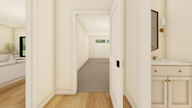 corridor with sink and light wood-type flooring