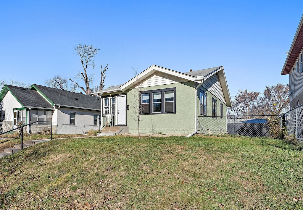 rear view of house featuring a lawn