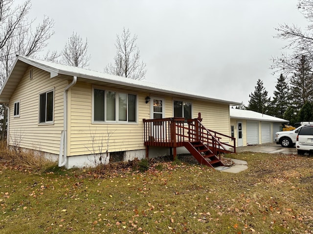 view of front of property with a front yard, an outdoor structure, and a garage