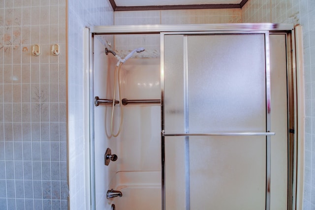 bathroom with combined bath / shower with glass door and crown molding