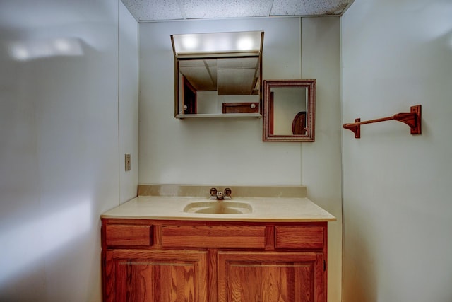 bathroom with a drop ceiling and vanity