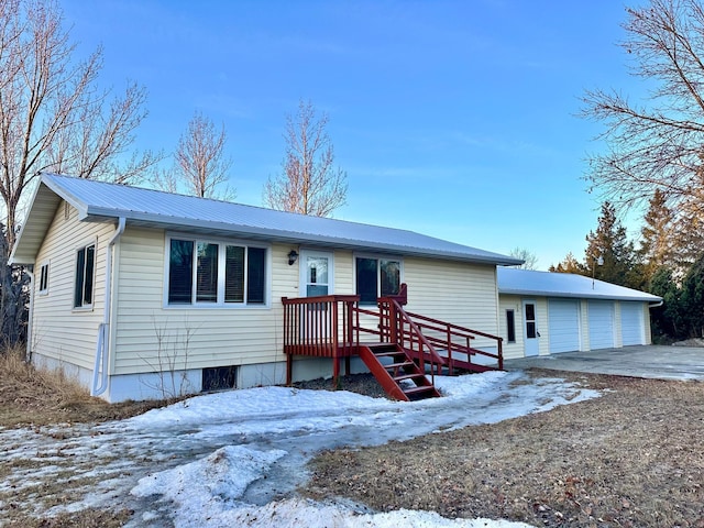 view of front of house featuring a garage, metal roof, and an outdoor structure