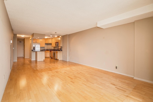 unfurnished living room featuring light hardwood / wood-style floors and a textured ceiling