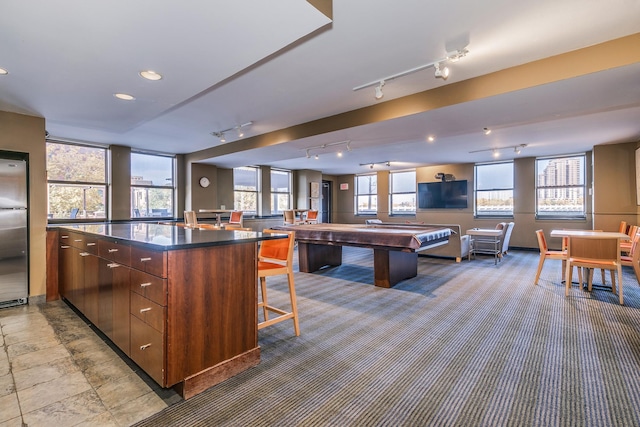 kitchen featuring a kitchen breakfast bar, pool table, stainless steel fridge, and a large island