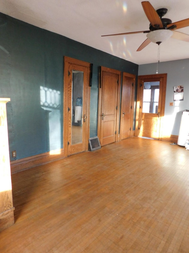 unfurnished living room featuring ceiling fan and light hardwood / wood-style floors