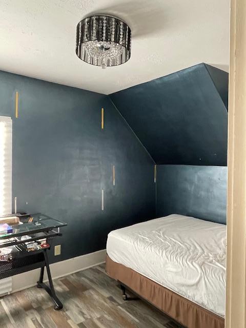 bedroom featuring wood-type flooring and lofted ceiling