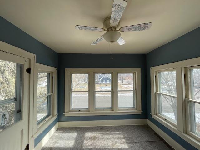 unfurnished sunroom featuring a wealth of natural light and ceiling fan