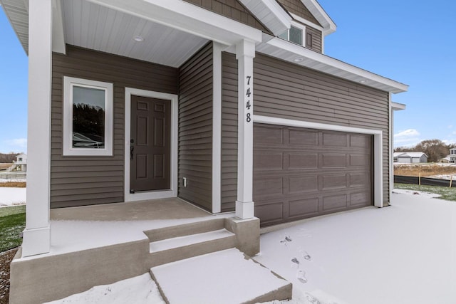 property entrance featuring a garage and covered porch