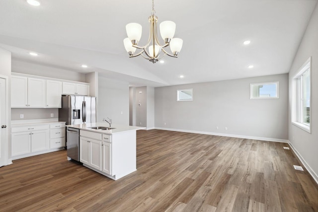 kitchen with white cabinetry, sink, stainless steel appliances, wood-type flooring, and decorative light fixtures