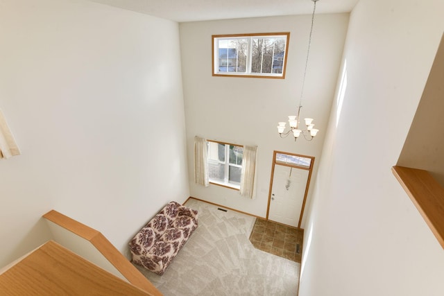 carpeted entrance foyer with a chandelier