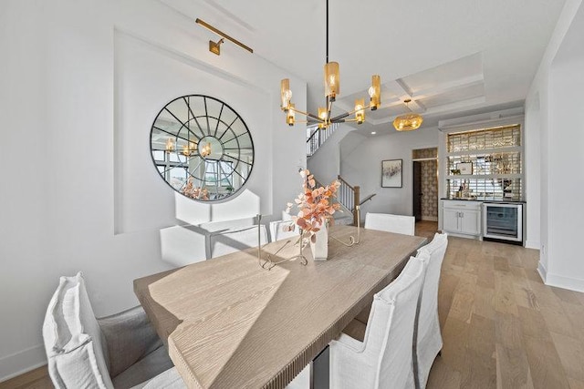 dining room with beverage cooler, light hardwood / wood-style flooring, beamed ceiling, bar area, and a chandelier