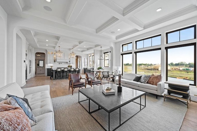 living room with beamed ceiling, light wood-type flooring, and coffered ceiling