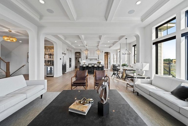 living room with beamed ceiling, wood-type flooring, beverage cooler, and a healthy amount of sunlight